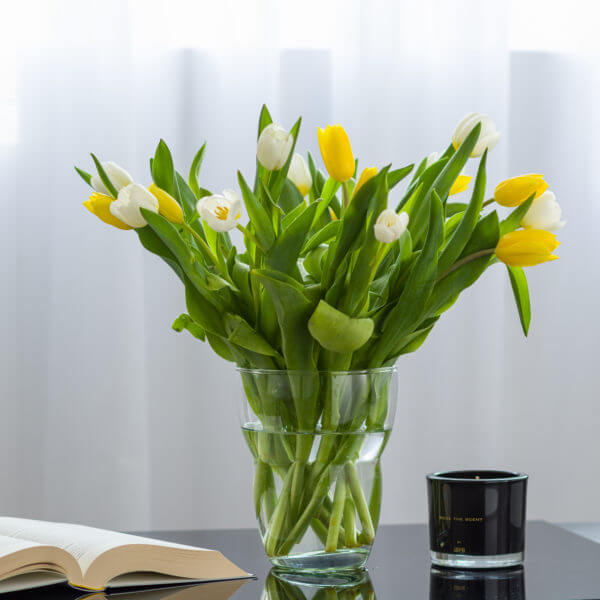 Wazon szklany cylinder z żółtymi kwiatami