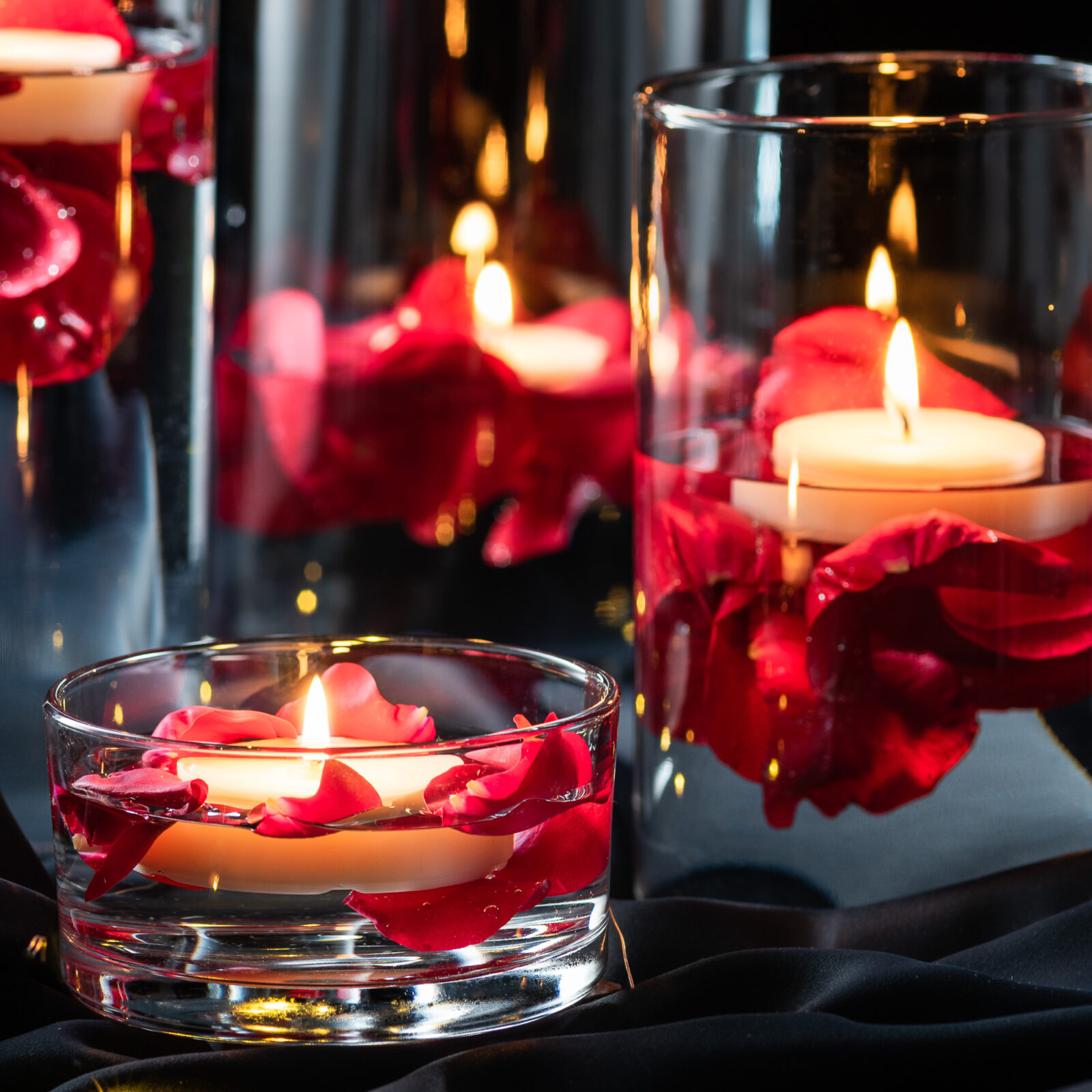 Świece i róże w zestawie szklanych wazonów tub