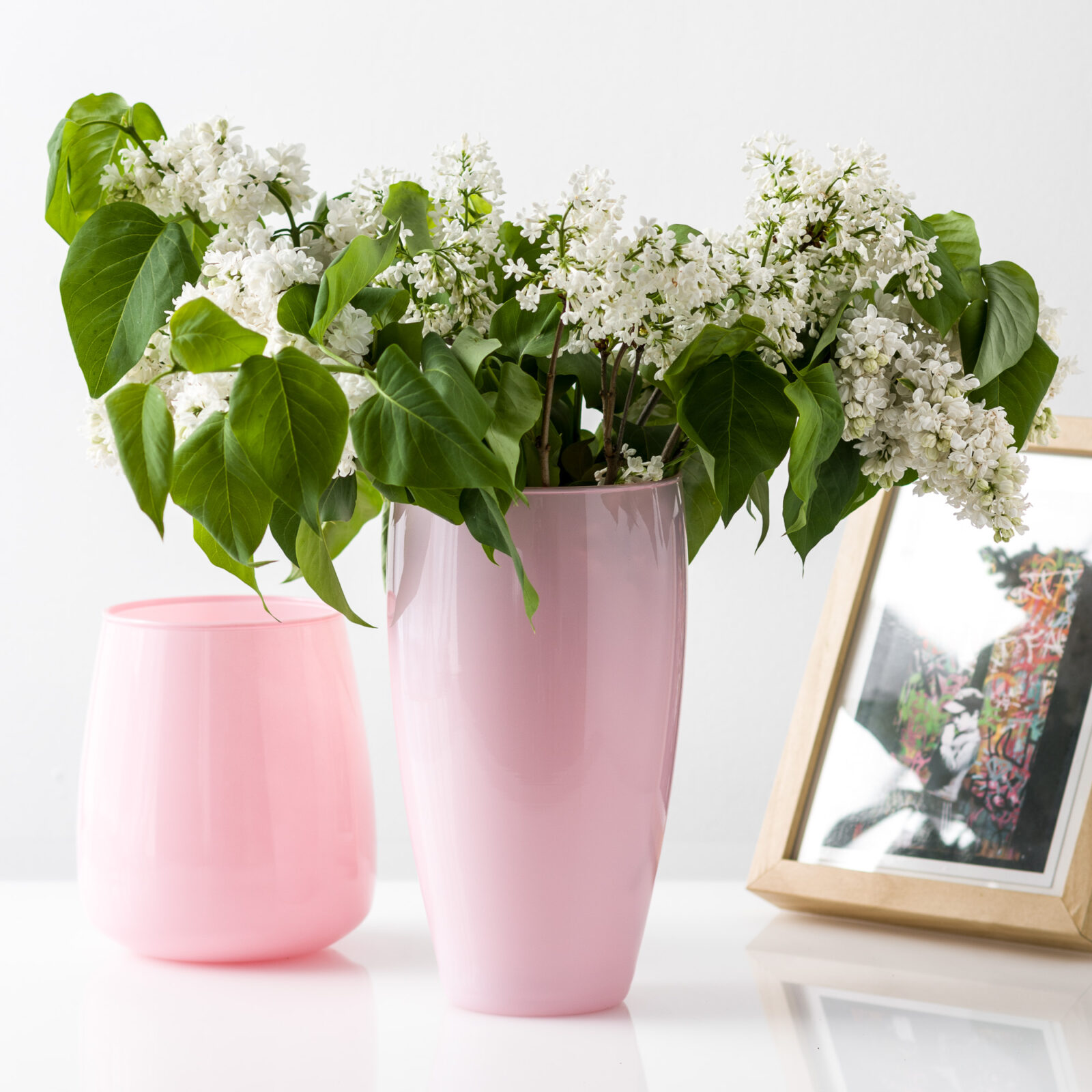 Różowy połyskujący wazon ozdobiony białymi kwiatami