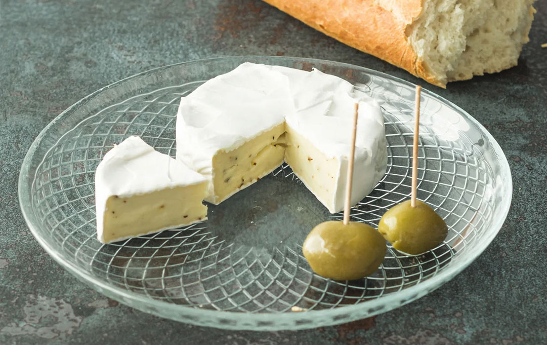 talerz deserowy szklany na stole z serem i oliwkami
