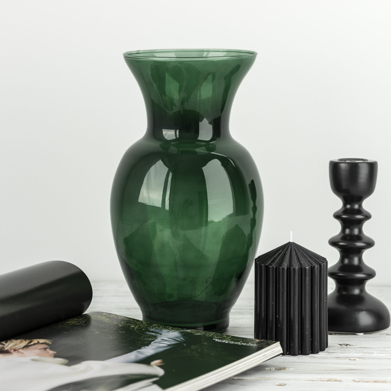 zielony wazon szklany z czarną świecą